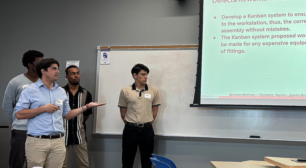 Industrial paint system staging presentation by Bradley University students, with Max Gomez and team sharing efficiency recommendations during Dr. Chen’s engineering course final exam